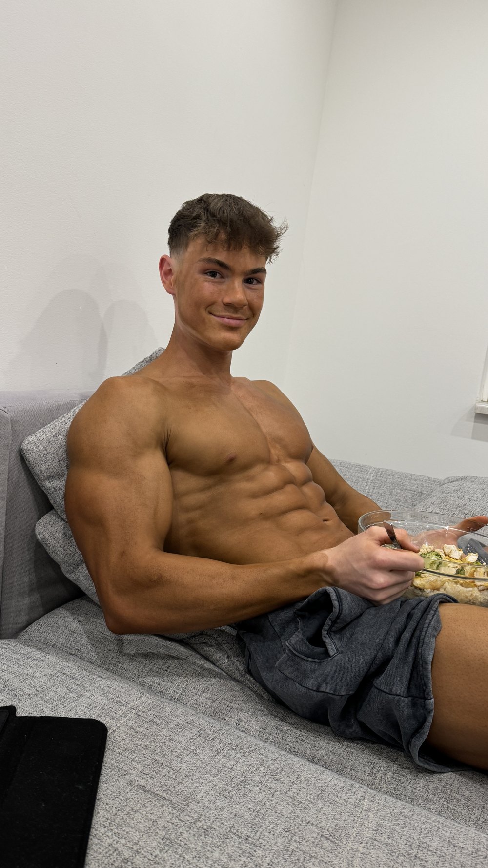 Tobi Krömmer zu Hause auf dem Sofa, eine Schüssel Essen in der Hand